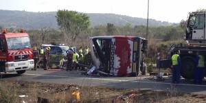 Emergency services personnel stand at the scene of a bus accident crashed on the AP7 highway that links Spain with France along the Mediterranean coast near Freginals halfway between Valencia and Barcelona early Sunday, March 20, 2016. The bus was reportedly hired out to carry students to and from a fireworks festival in Valencia and was on the return leg of its journey when the accident happened. (AP Photo)